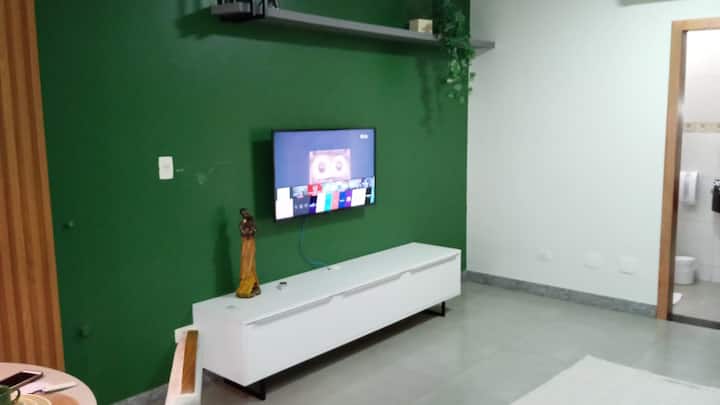 Sala de TV com parede verde e rack moderno