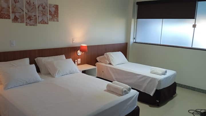 Quarto com duas camas de solteiro e quadros decorativos